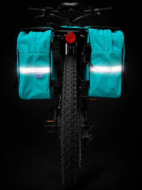 Alforje 40L Bike Baslu azul tiffany instalado no bagageiro da bicicleta, vista frontal com refletivos