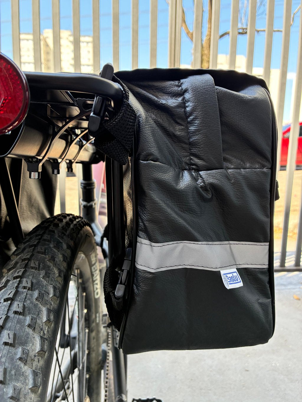 Alforje 40L Bike Baslu preto, detalhe da etiqueta da marca e da faixa refletiva