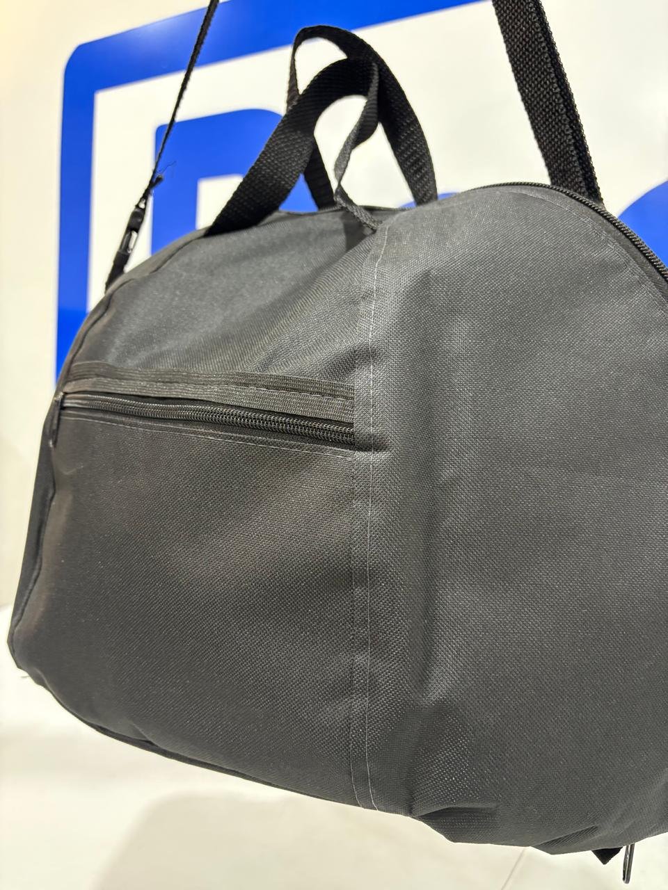 Detalhe do tecido e bolso frontal da bolsa porta capacete Baslu preta